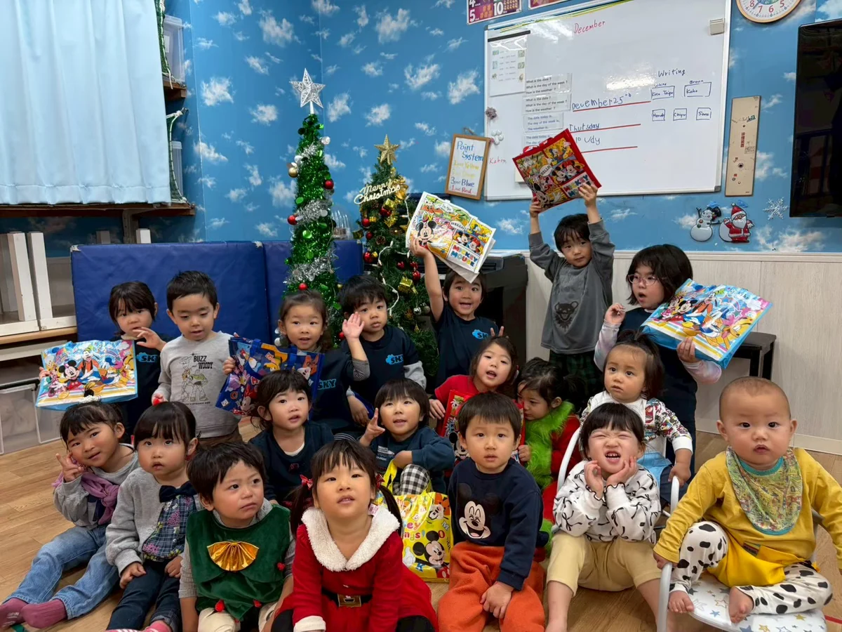 クリスマスツリーの前で集まる子どもたち