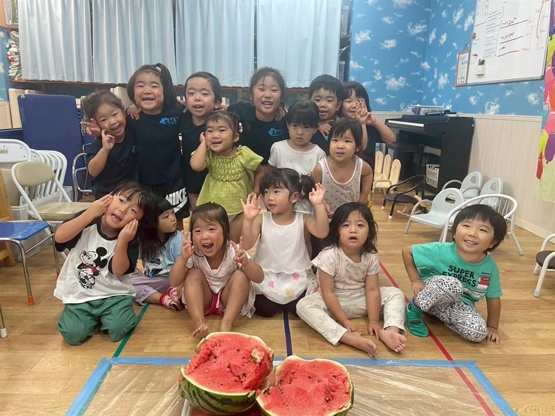 すいかを囲んで夏の活動を楽しむ子どもたち