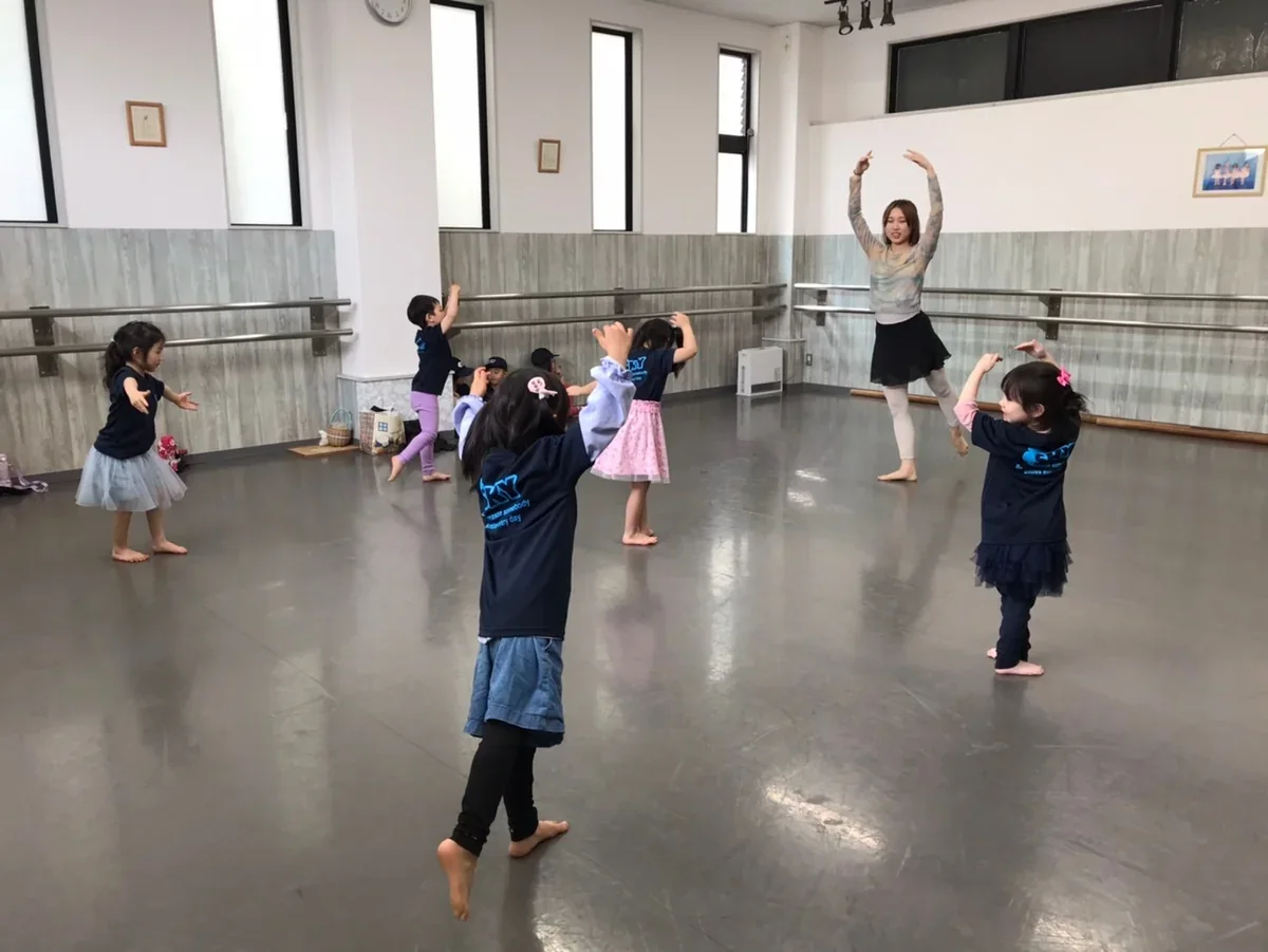 バレエの先生と一緒に体で表現する子どもたち